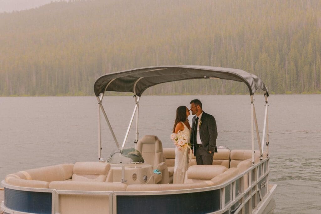 Bride and groom riding in a boat at one of the most unique Idaho wedding venues with waterfront access